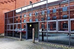 Laboratory of the Paul-Gordan-Str. 7. Adjacent to the red bricks of a building, a window front reflects the facade of the institute building opposing it.